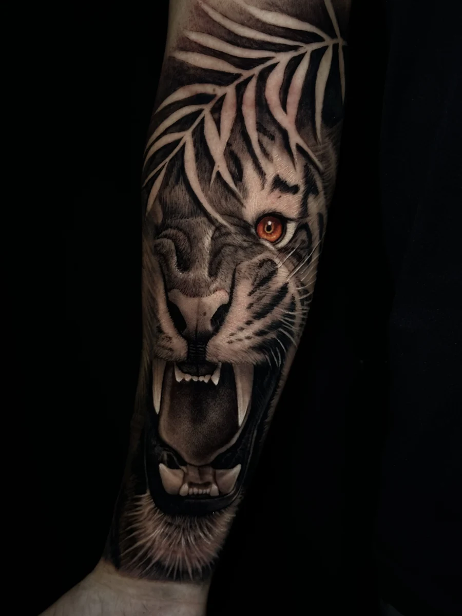 Tatuagem realista de tigre rugindo com folhas, braço, preto e cinza